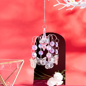 Close-up of iridescent crystal beads and silver butterfly charms on a hanging suncatcher.