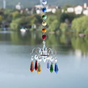 Close-up of rainbow crystal suncatcher chandelier pendant hanging in outdoor garden scene.