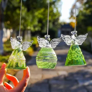 Vue détaillée d'anges suspendus en verre de cristal faits main avec décors de perles vertes.
