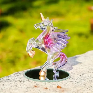 Detailed view of a clear crystal unicorn figurine with purple wings and gold accents