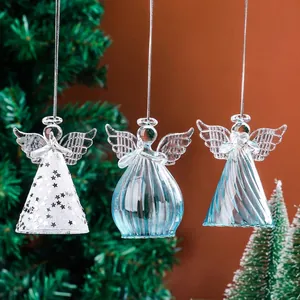 Détail de trois ornements d'anges en verre transparent suspendus au sapin de Noël