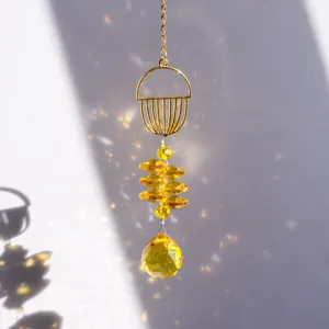 Close-up of a golden jellyfish crystal suncatcher reflecting rainbow light spots on wall