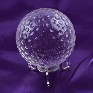 Close-up of K9 crystal golf ball with detailed concave dimple pattern on stand