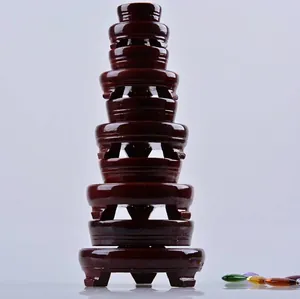 Stack of glossy dark red wooden display bases for crystal balls and ornaments