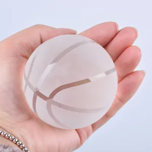 Detailaufnahme eines dekorativen Basketball-Ornaments aus gefrostetem Kristall in der Hand.