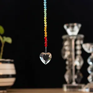 Detailed view of clear faceted crystal heart pendant suspended from a vibrant rainbow bead string