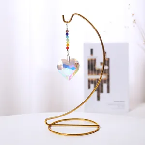 Atrapasol de cristal en forma de corazón con cuentas de arco iris en un elegante soporte dorado