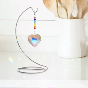 Vista detallada de un atrapasol de cristal con forma de corazón en soporte