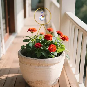 Paletto da giardino acchiappasole in cristallo che riflette la luce in un vaso di fiori