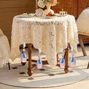 Elegant teardrop crystal tablecloth weights hanging from a decorative lace cloth