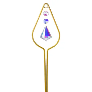 Close-up of golden teardrop garden stake with faceted crystal suncatcher prism