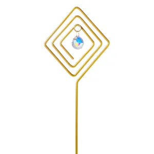 Detail of a golden spiral diamond garden stake with an iridescent faceted crystal ball