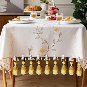 Close-up of nine yellow crystal teardrop tablecloth weights with silver metal clips
