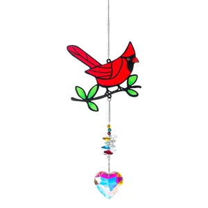 Detail van rode kardinaal zonnevanger met regenboog hartvormig kristallen prisma