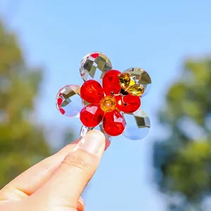 Close-up of a sparkling crystal flower and ladybug garden ornament held by hand