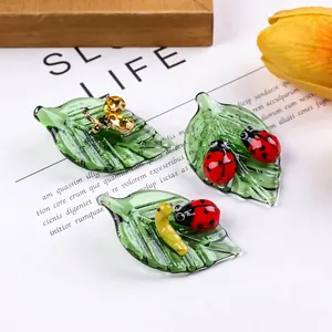Handcrafted macro detail of crystal glass leaf ornaments with ladybug and bee figurines