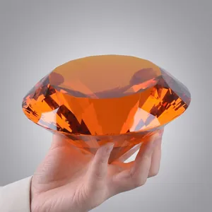 Élégant presse-papier diamant en cristal ambré de 100 mm tenu en main pour l'échelle