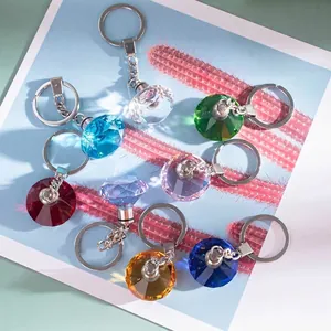 Nahaufnahme von bunten facettierten Kristall-Diamant-Schlüsselanhängern mit LED-Licht und Ring
