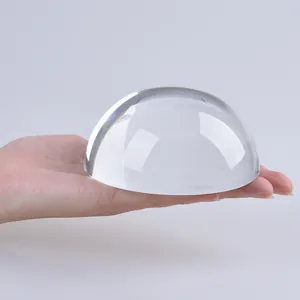Presse-papier en demi-sphère de verre cristal clair tenu à la main pour l'échelle