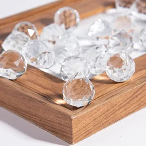 Detailed macro view of faceted transparent crystal glass lamp balls on a wooden tray