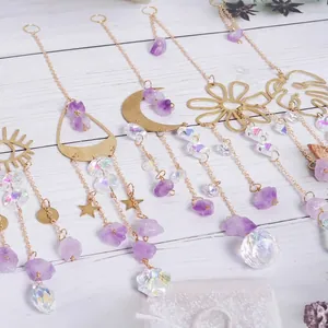 Close-up of purple stone and crystal suncatchers with gold moon and flower shapes