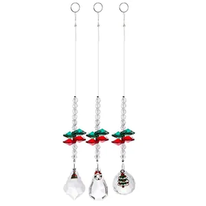 Vue détaillée de trois attrape-soleil en cristal à facettes avec breloques de Noël festifs