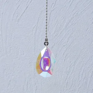 Detail view of a shimmering iridescent AB crystal teardrop pendant with a silver bead chain