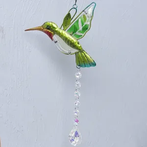 Close-up of green metallic hummingbird suncatcher with hanging crystal pendant