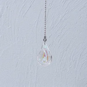 Close-up view of a faceted teardrop crystal pendant with AB coating and bead chain