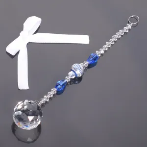 Nahaufnahme eines blau-klaren Kristallornaments mit einer facettierten Anhängerkugel.