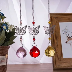 Detailed view of three colorful faceted crystal balls with metal butterfly accents for hanging