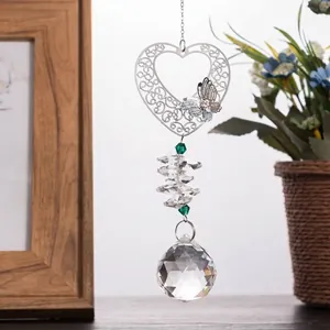 Detailed view of a silver heart filigree pendant with faceted clear crystal ball