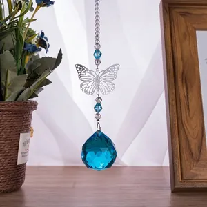 Close-up of blue faceted crystal ball suncatcher with metal butterfly ornament
