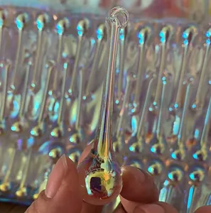 Close-up of an iridescent teardrop crystal pendant showing a glossy, multi-colored finish.