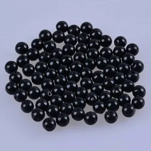 Vue macro de perles en verre noir poli avec trous pour la création de bijoux DIY