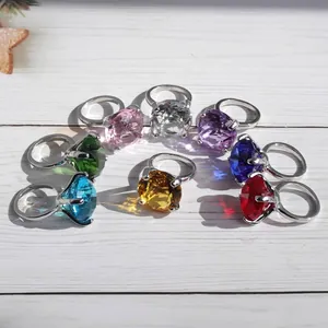 Detailed shot of various colorful oversized crystal rings on a white wood surface