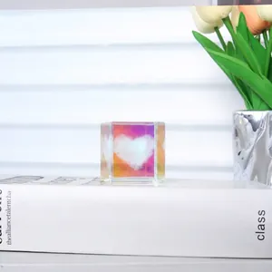 Primer plano de un cubo de cristal K9 con corazón grabado en 3D y fondo iridiscente
