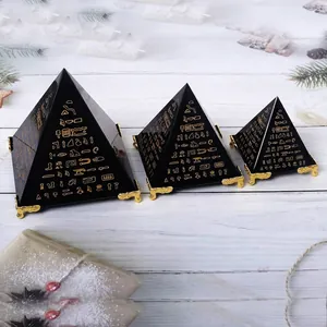 Gedetailleerd overzicht van drie zwarte piramide-ornamenten met gouden hiërogliefengravures