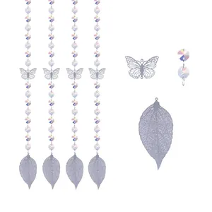 Detalle de cuentas de cristal con colgantes metálicos de mariposa y hoja
