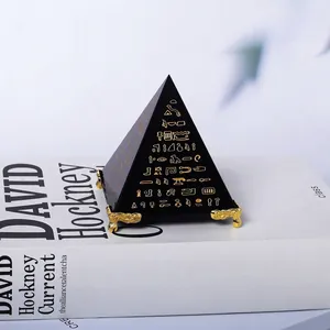 Gedetailleerd overzicht van een zwarte decoratieve piramide met gouden hiërogliefen op boek