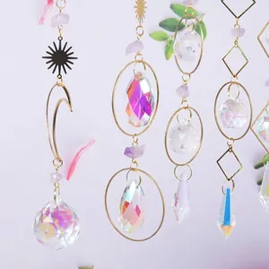 Detalle de atrapasoles de cristal arcoíris con piedras púrpuras y formas de luna dorada