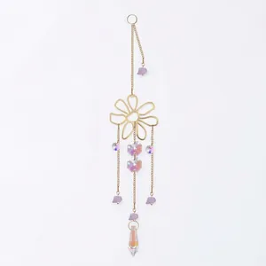 Close-up of golden flower suncatcher with decorative purple stones and AB crystal prism