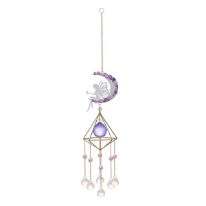Détail d'un attrape-soleil en cristal lune avec silhouette de fée et pierres violettes