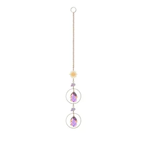 Primer plano de un atrapasol de cristal AB con piedras moradas y dije de sol dorado.
