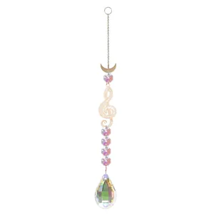 Detail view of iridescent crystal suncatcher with gold moon and music note charms