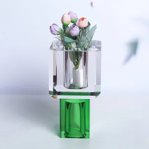 Detailansicht einer quadratischen Kristallvase mit grünem Boden und kleinen Kunstrosen
