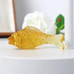 Detailed side view macro shot of a decorative golden amber crystal fish glass figurine
