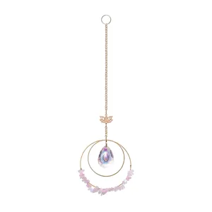 Macro detail of a crystal suncatcher hanging ornament with lotus charm and pink crushed stones