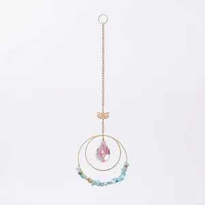 Close-up detail of gold lotus suncatcher featuring blue crushed stones and iridescent teardrop crystal