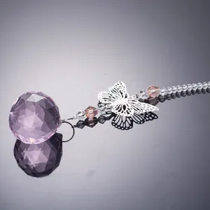Close-up detail of a faceted crystal ball pendant with a silver metal butterfly